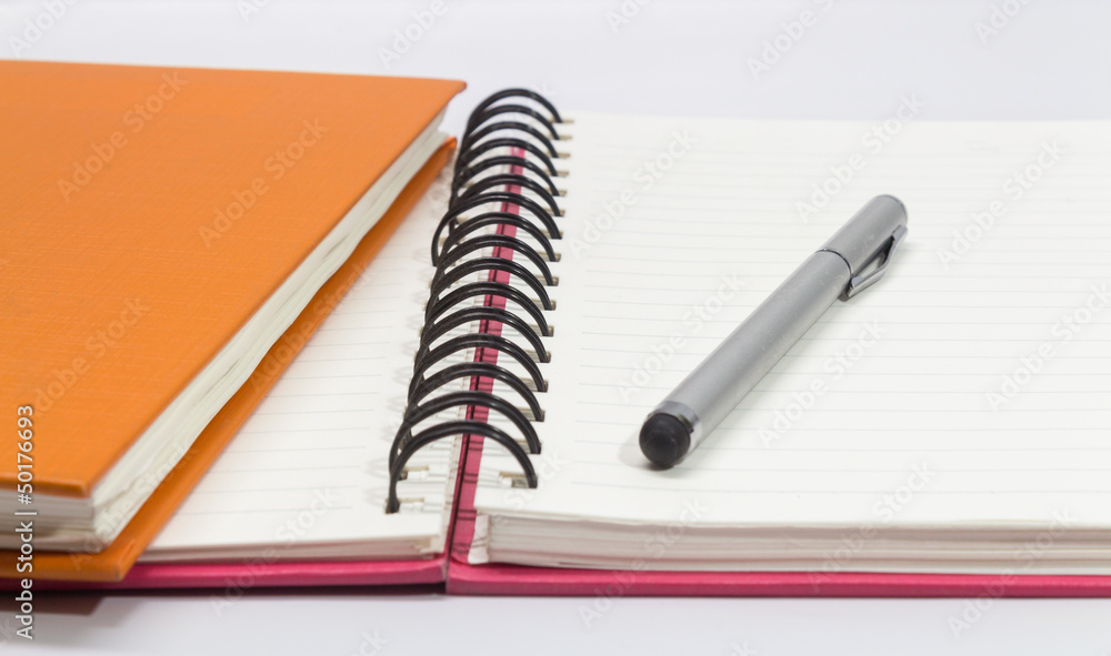 Close-up of pink, orange open note book and pen Close-up of pink, orange open note book and pen