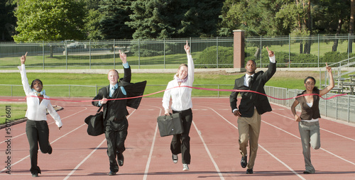Business people running across track finish line