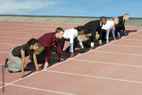 Business people crouching at starting line on track
