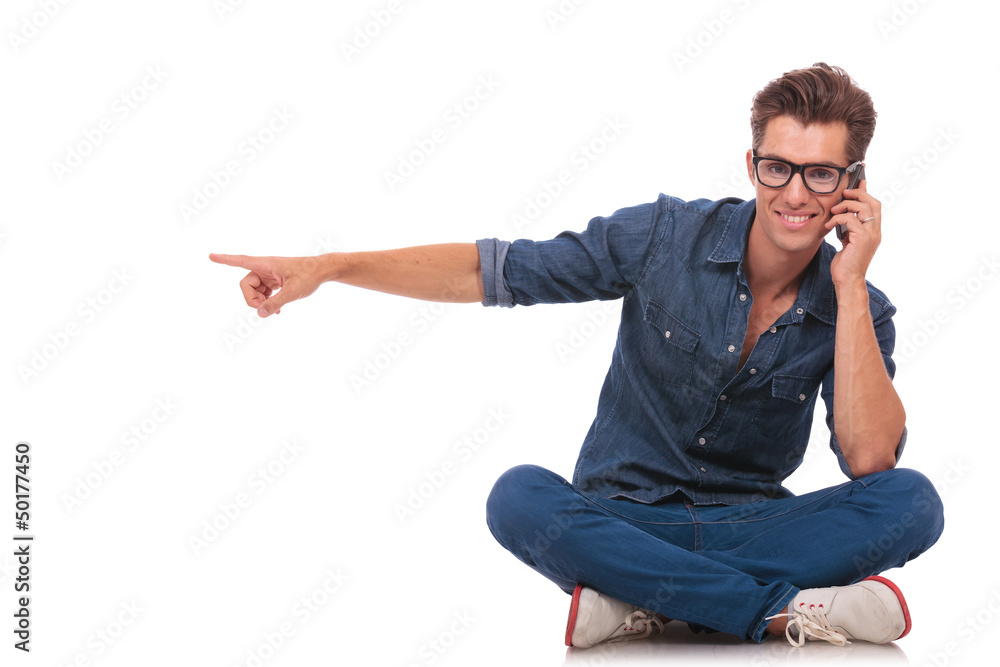 seated man on phone points to side seated man on phone points to side