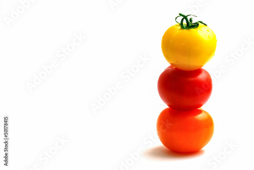 multicolored tomatoes placed one upon the other photo