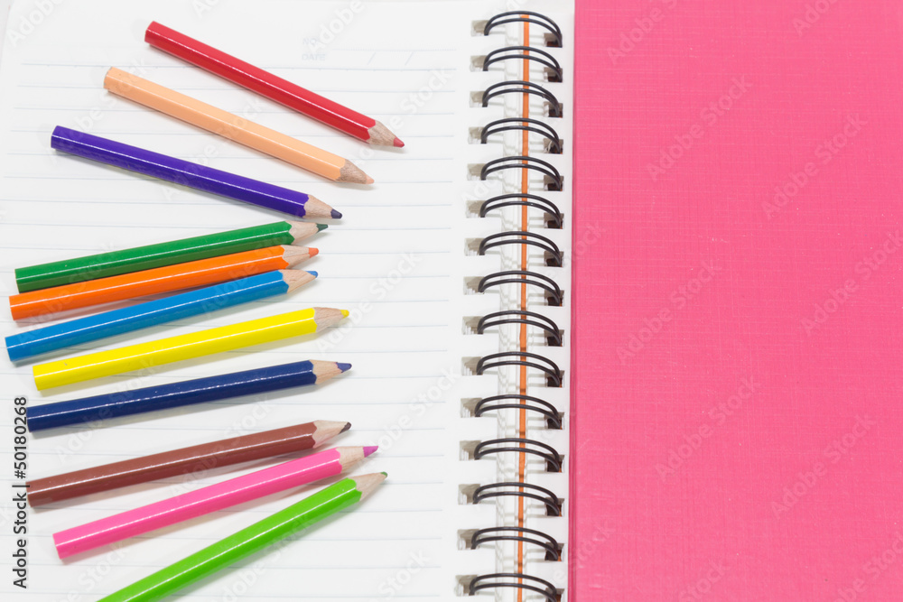 Close-up of pink orange note book and colored pencils, student d Close-up of pink orange note book and colored pencils, student d