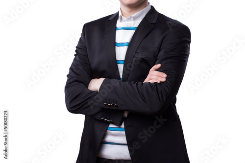 A businessman stands with his arms crossed