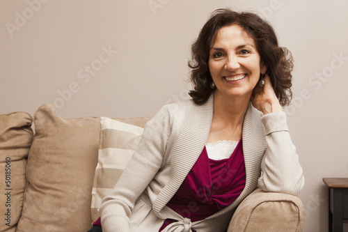 Smiling Caucasian woman sitting on sofa photo