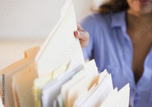 Cape Verdean woman picking up file folder photo