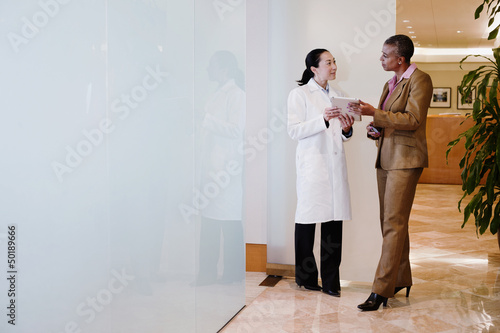 Doctor and businesswoman using digital tablet