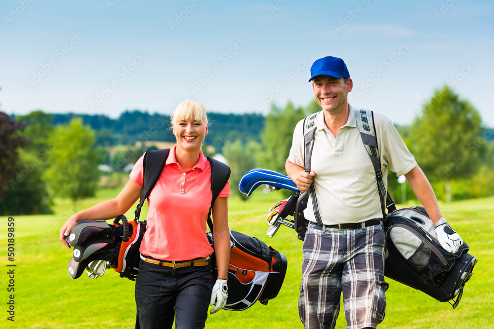 Young sportive couple playing golf on a course Young sportive couple playing golf on a course