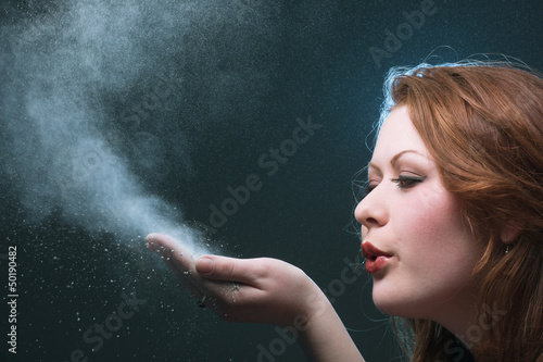 The girl blows off a dust from a palm