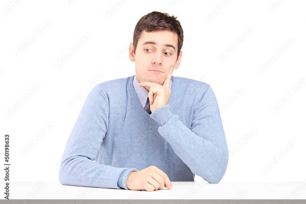 Worried young man sitting at a desk Worried young man sitting at a desk