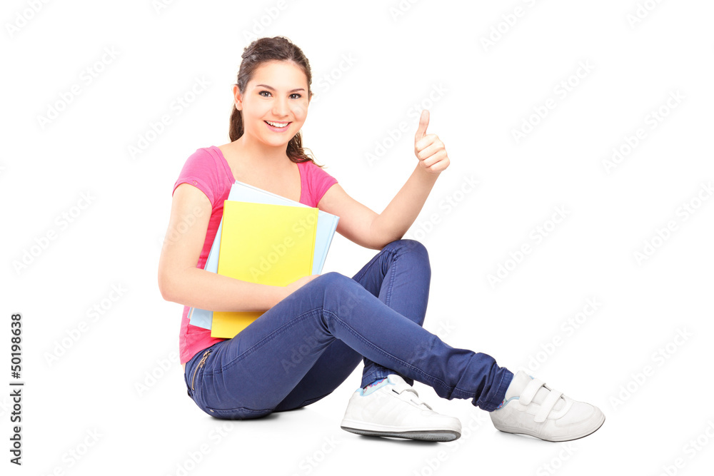 Young female student sitting on floor and giving thumb up Young female student sitting on floor and giving thumb up