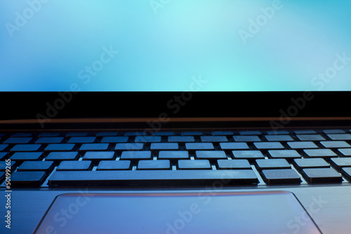 close up of laptop keyboard as a background toned to blue
