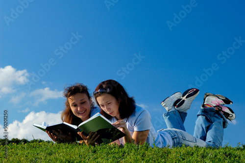 Two girls reading books outside photo