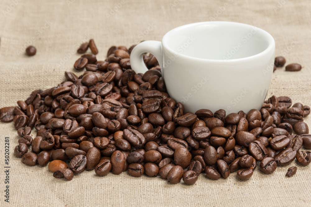 heap of coffee beans on burlap with cup heap of coffee beans on burlap with cup