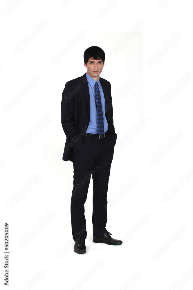Businessman stood with his hands in his pockets