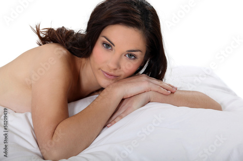 Portrait of a nude woman lying on a bed photo
