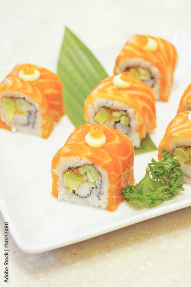 Sushi salmon roll on white dish Sushi salmon roll on white dish