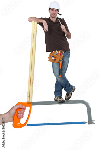 Builder standing on a saw photo