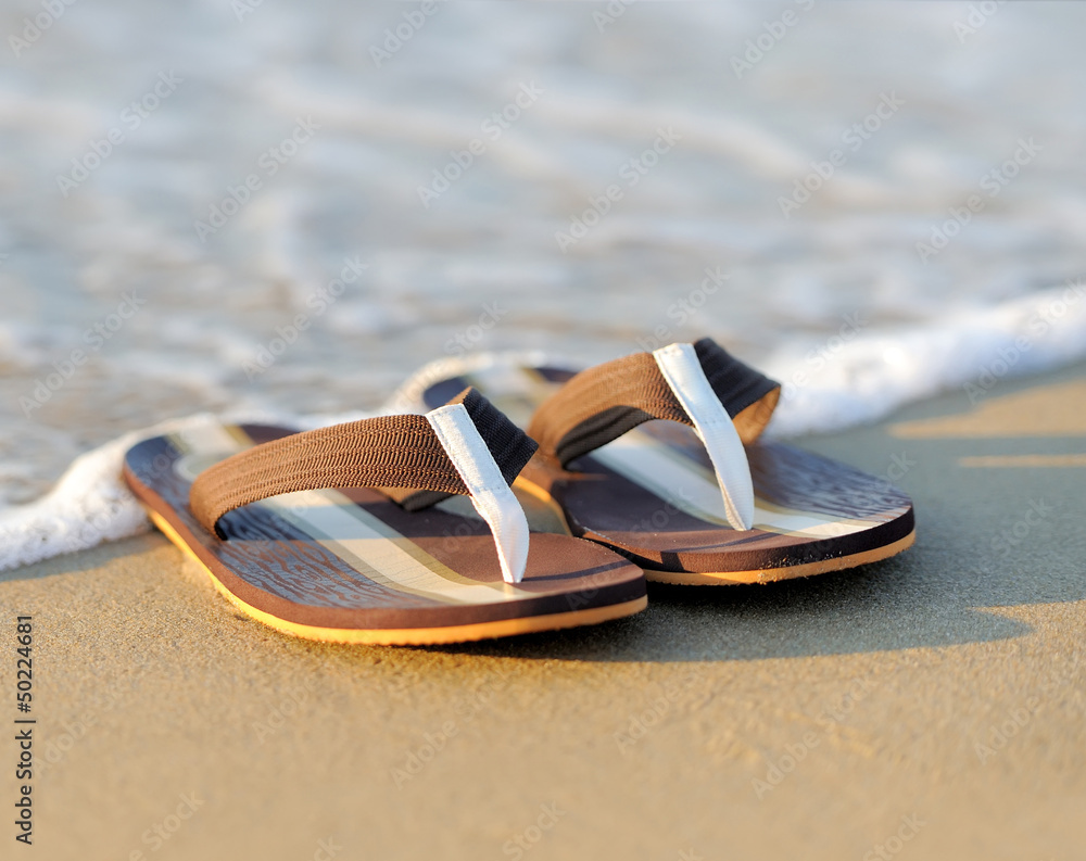 Flip flops on a sandy ocean beach Flip flops on a sandy ocean beach