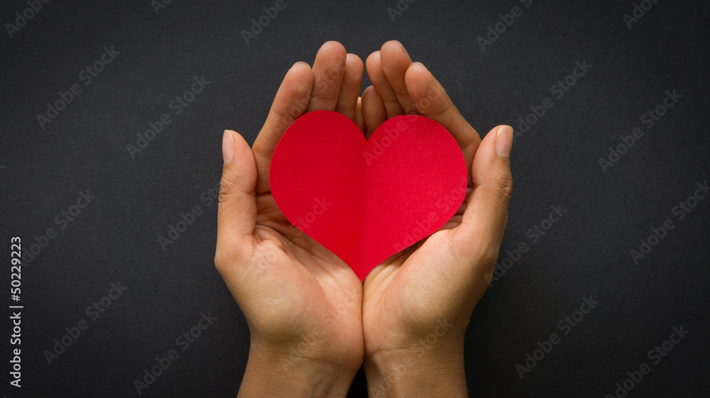 Hands holding a red paper heart Hands holding a red paper heart