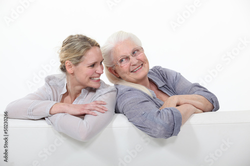 Two women on a white sofa