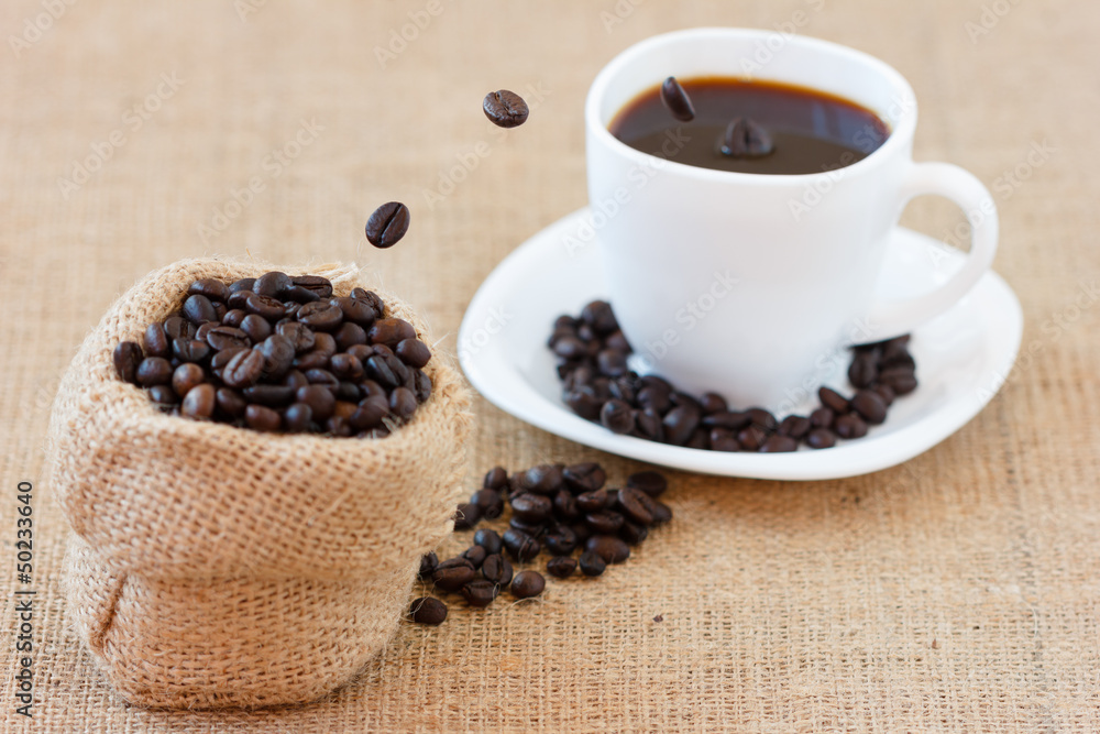 Coffee beans jumping into white cup Coffee beans jumping into white cup