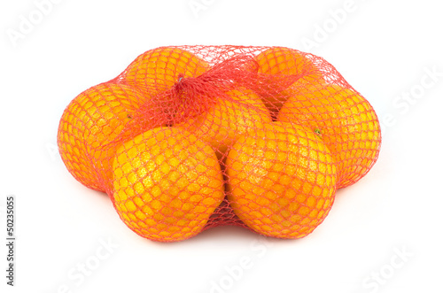Oranges in red net isolated on white closeup