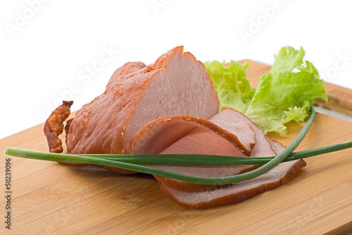 Baked ham with slices on wooden board on white background