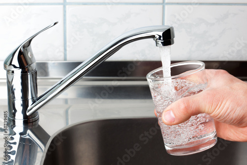 Glass filled with drinking water from kitchen faucet.