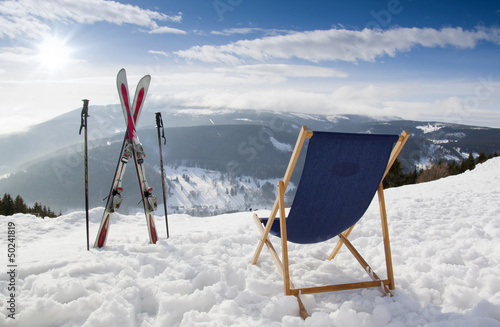 Cross ski and Empty sun-lounger at mountains in winter
