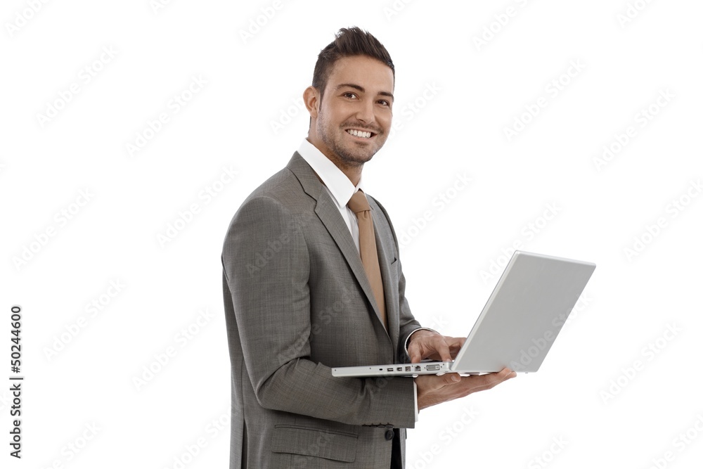 Young businessman using laptop smiling Young businessman using laptop smiling