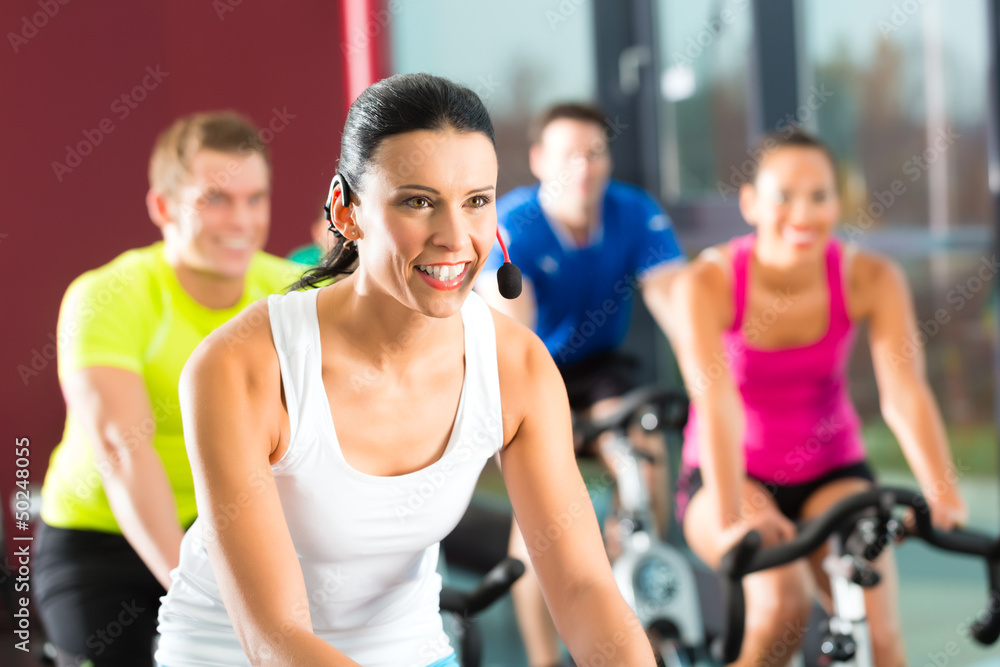 Group of people spinning on bikes in gym Group of people spinning on bikes in gym