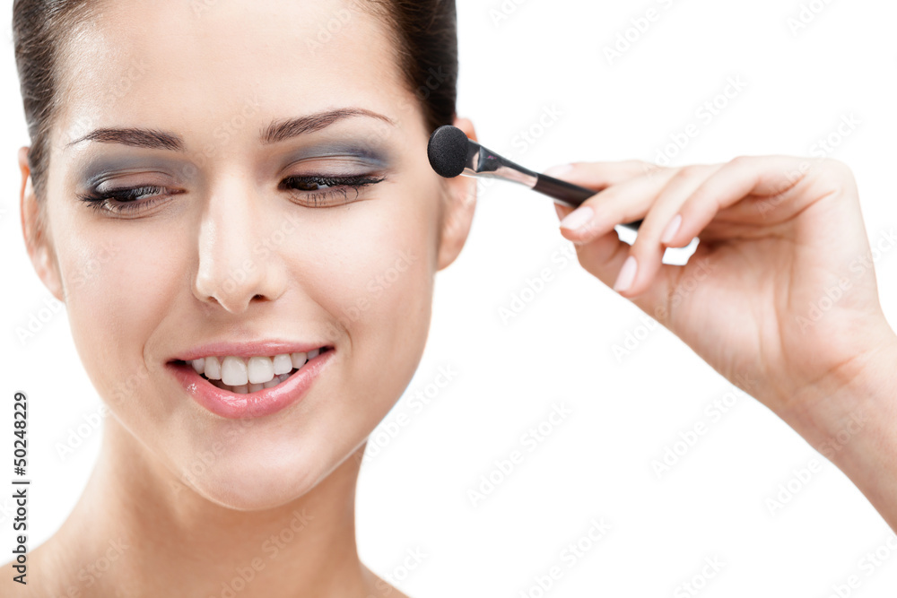 Woman applying makeup with cosmetic brush