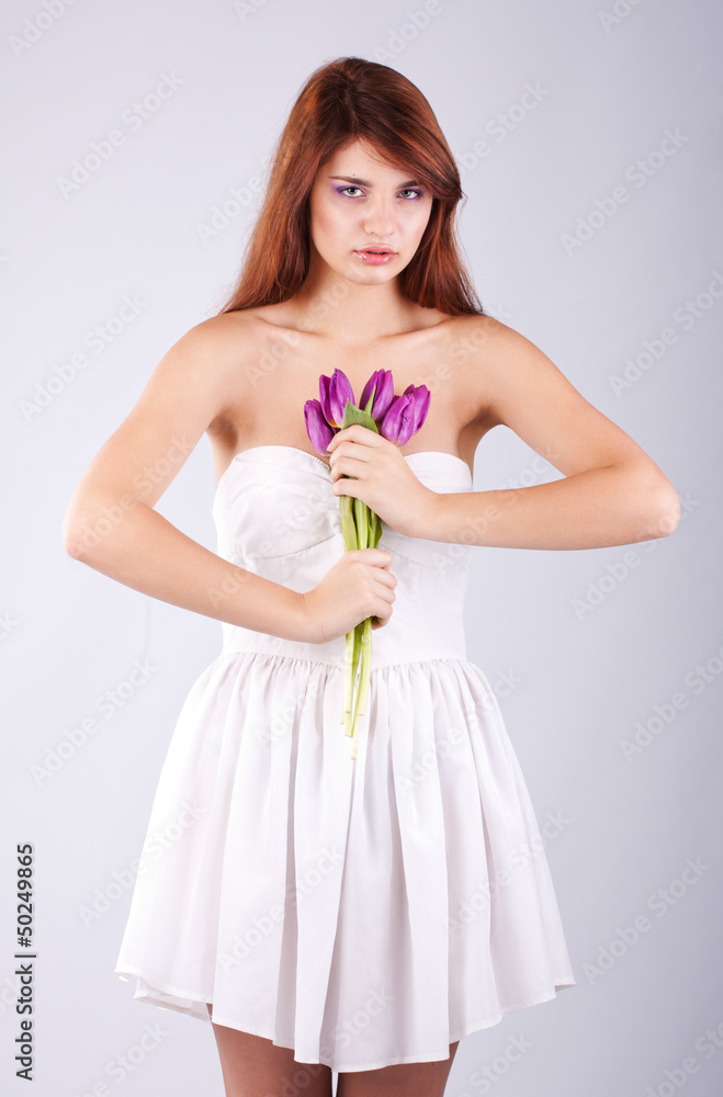 Beautiful girl with bunch of spring flowers