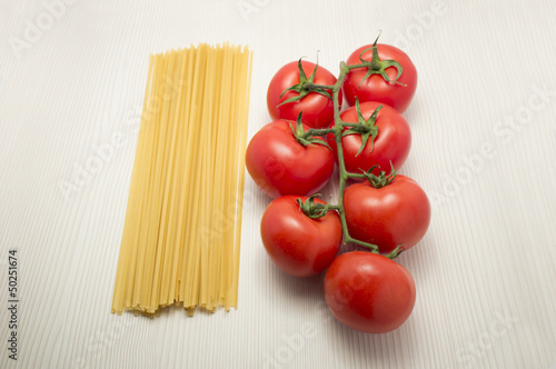 spaghetti and tomatoes on a table ready to cook