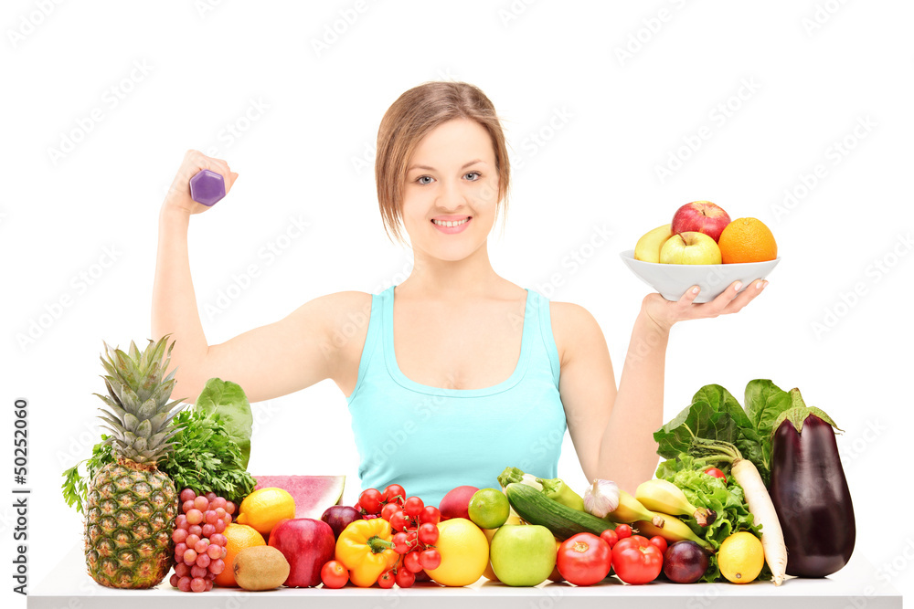 Beautiful young female holding a dumbbell and posing behind a pi Beautiful young female holding a dumbbell and posing behind a pi