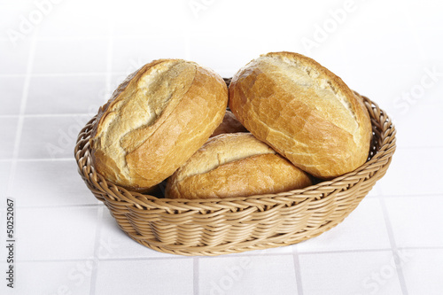 Korb mit Brötchen auf Damastdecke
