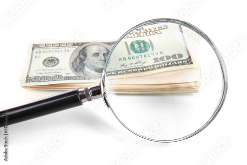 Hundred dollar bill and magnifying glass isolated on white