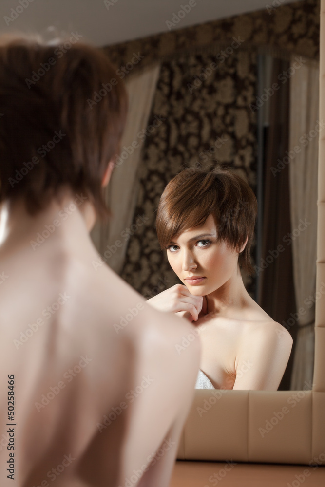 Naklejka premium Reflection of attractive young brunette in mirror