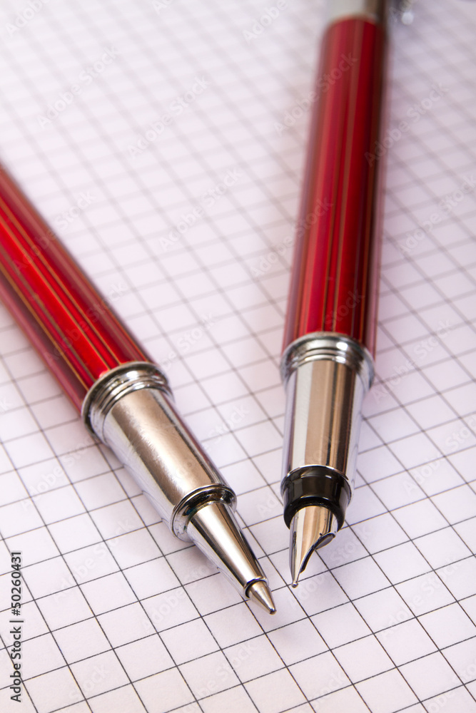 two pens on a notebook close up two pens on a notebook close up