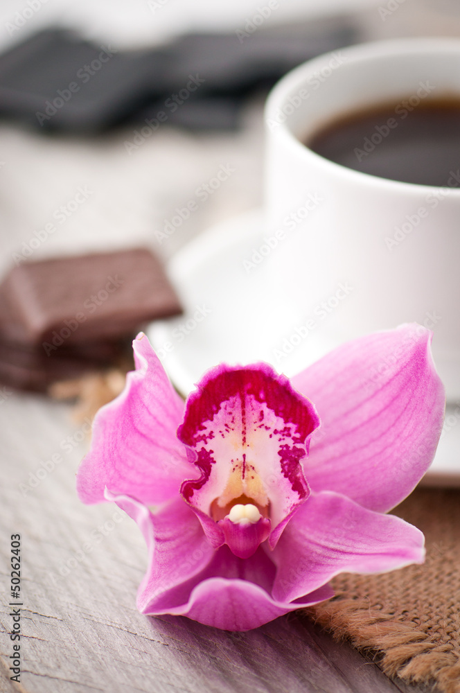cup of coffee, chocolate and orchid on wooden background cup of coffee, chocolate and orchid on wooden background