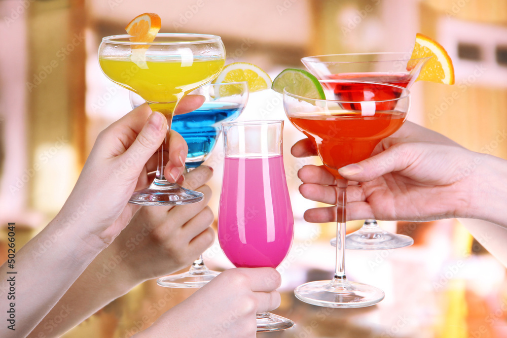 Cocktails in hands in cafe