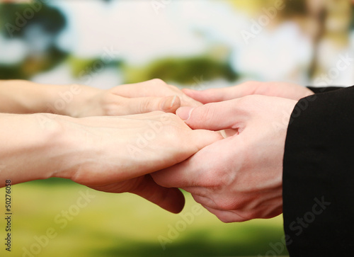 Priest holding woman hands, on green background © Africa Studio