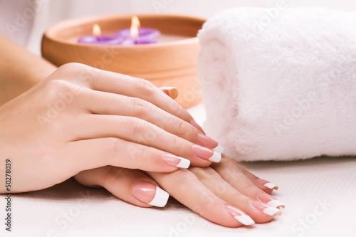 female hands with aromatic candles and towel. Spa