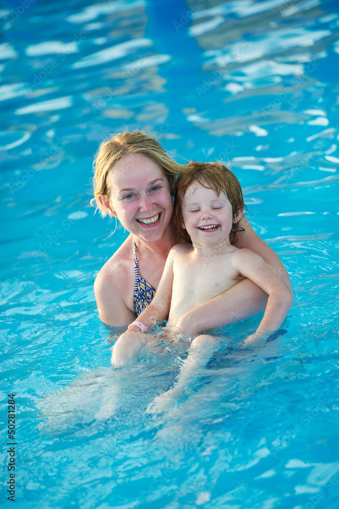 Woman and child in resort swimming pool