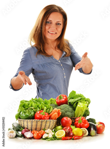 Young woman with variety of vegetables isolated on white