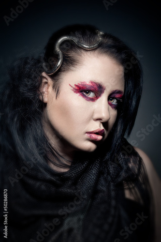 portrait of young brunette woman with fashion makeup on dark bac