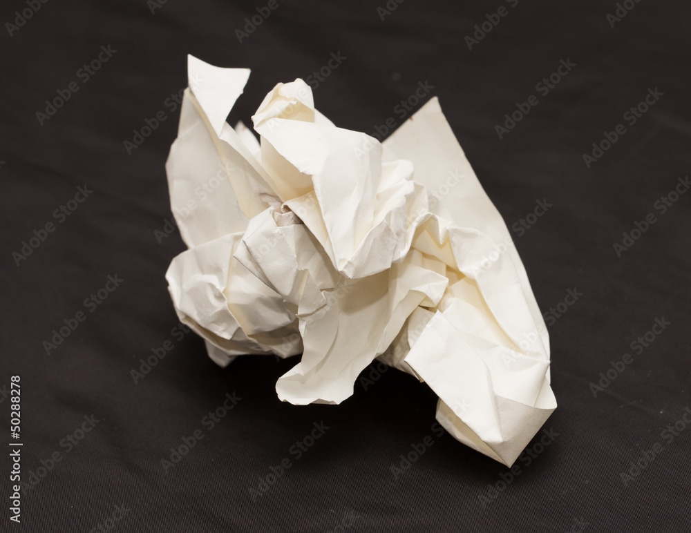 A crumpled paper ball in a black background A crumpled paper ball in a black background