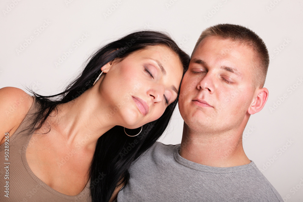 Beautiful pensive man woman stand near closed eyes gray wall Beautiful pensive man woman stand near closed eyes gray wall