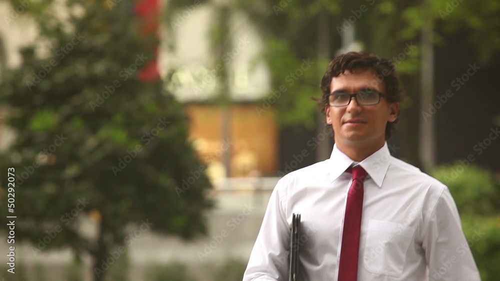A businessman stays with a laptop outside A businessman stays with a laptop outside
