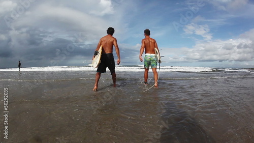 A guys goes to water to surf